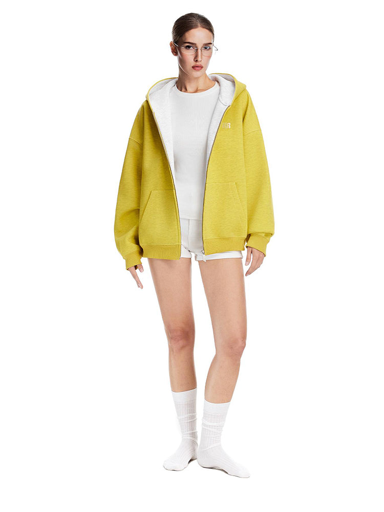 Full body shot of a model styling a yellow oversized hoodie with white lining and high socks, urban Y2K vibe.