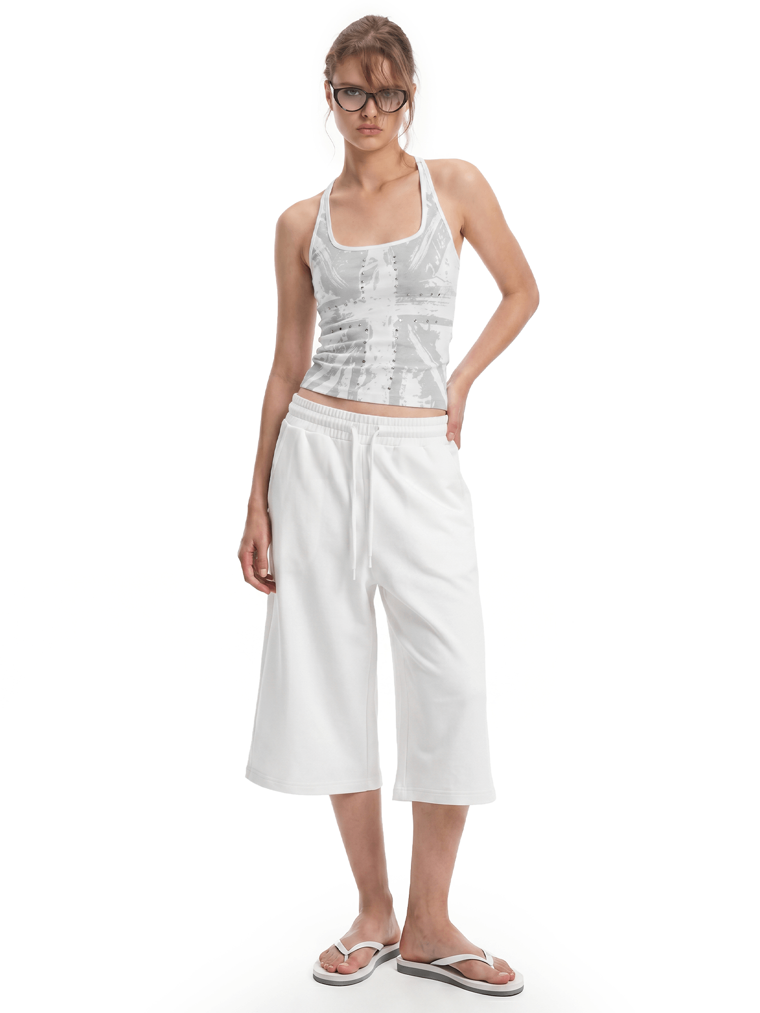 FDR Studios cyber Y2K white graphic halter neck cami with relaxed-fit white wide-leg cropped sweatpants.