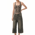 Model wearing FDR Studios earth-tone streetwear halter top with abstract print and loose-fit distressed capri pants.