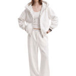 Front view of a model wearing a unisex off-white high-street streetwear tracksuit, featuring an oversized zip-up hoodie with a textured lining and matching baggy sweatpants.