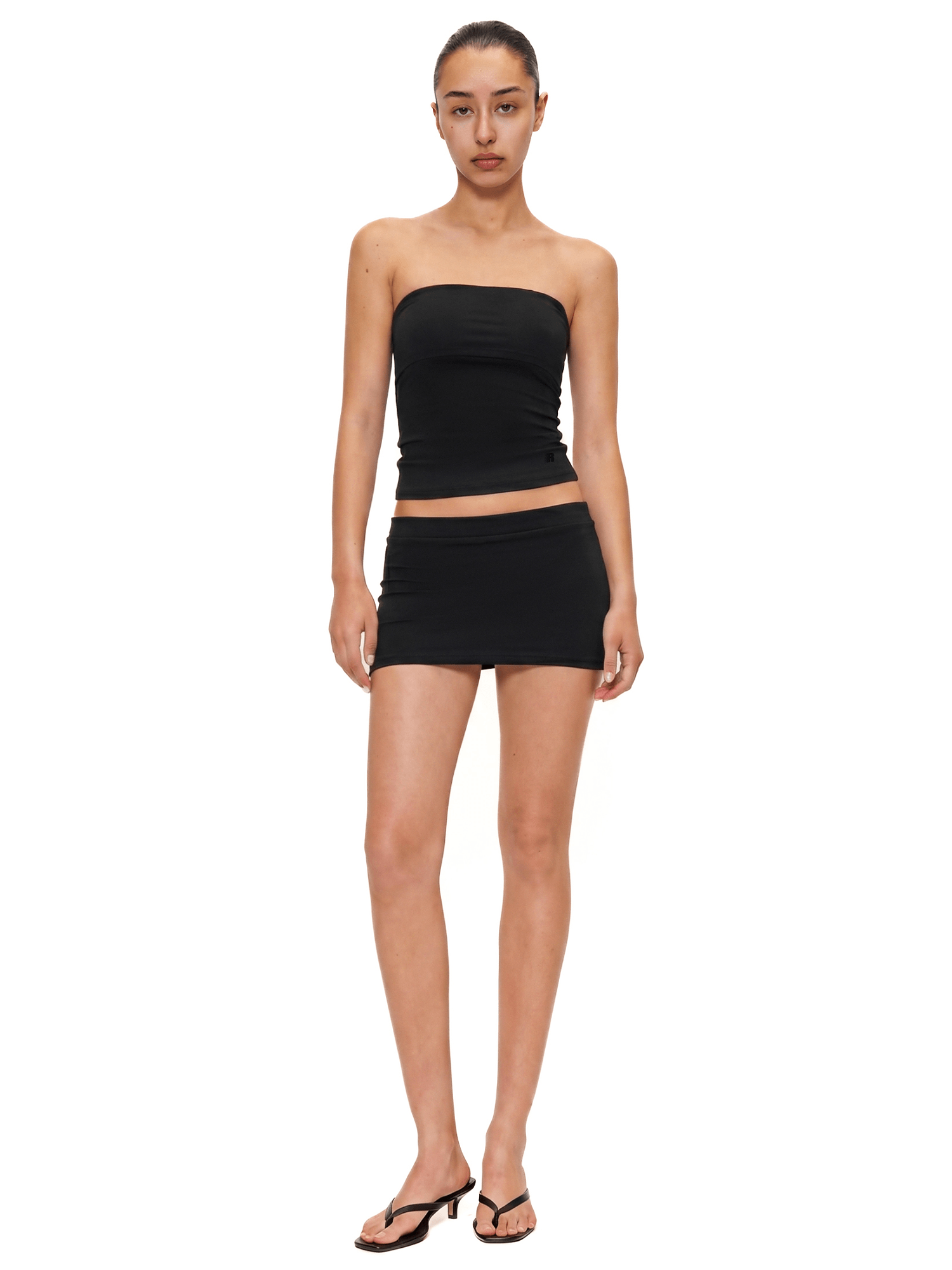 Full-body view of FDR Studios faded black seamless double-lined tube top and tight mini skirt two-piece set, industrial minimalist streetwear.