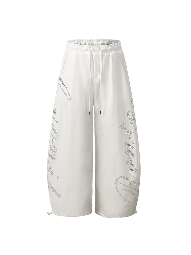 Angled view of baggy white joggers highlighting the voluminous wide-leg silhouette.