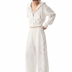 Full body side view of woman in baggy white streetwear coordinates.