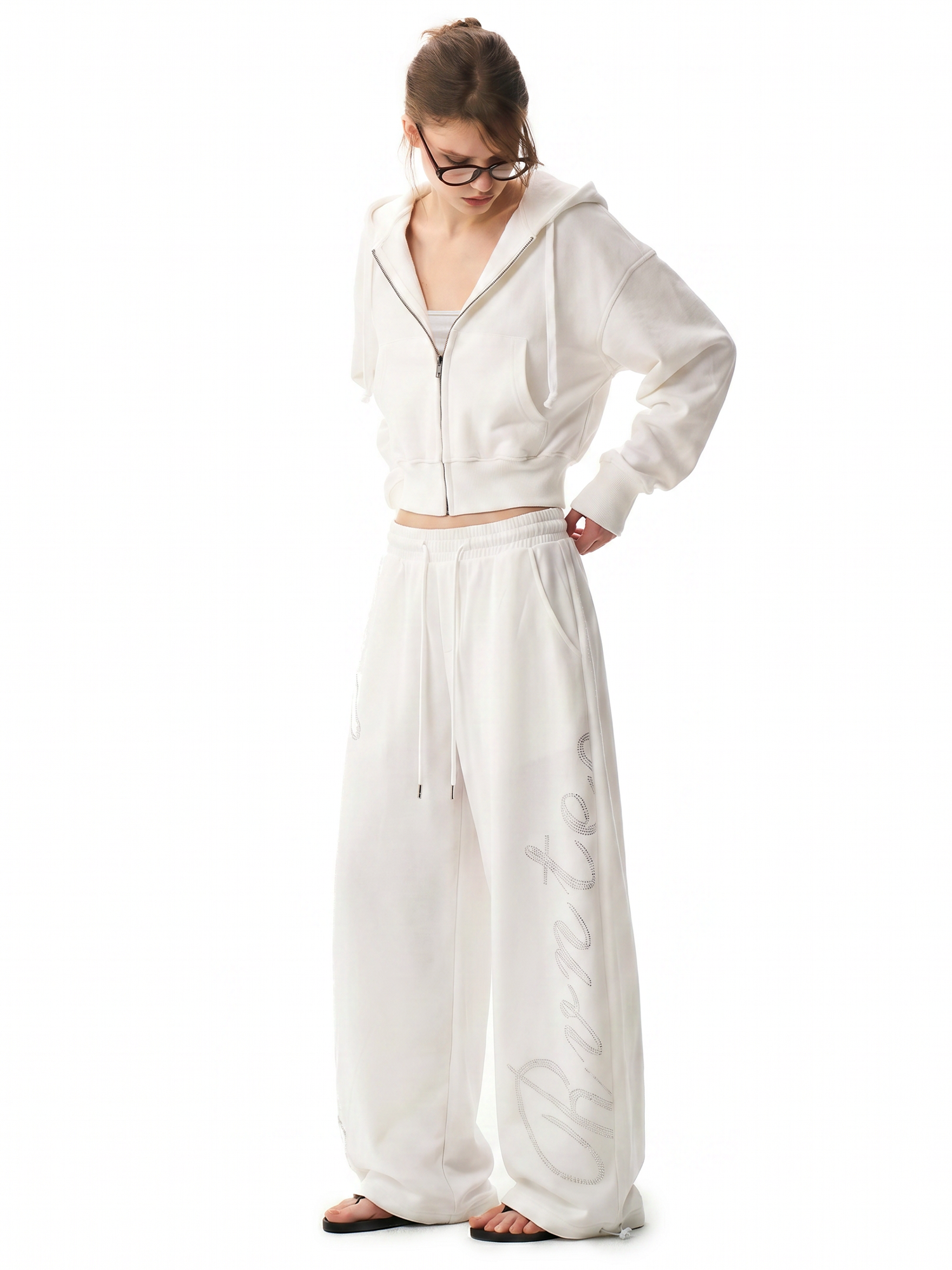 Full body side view of woman in baggy white streetwear coordinates.