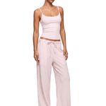Model wearing FDR Studios cyber Y2K soft baby pink camisole vest and baggy high-waisted sweatpants.