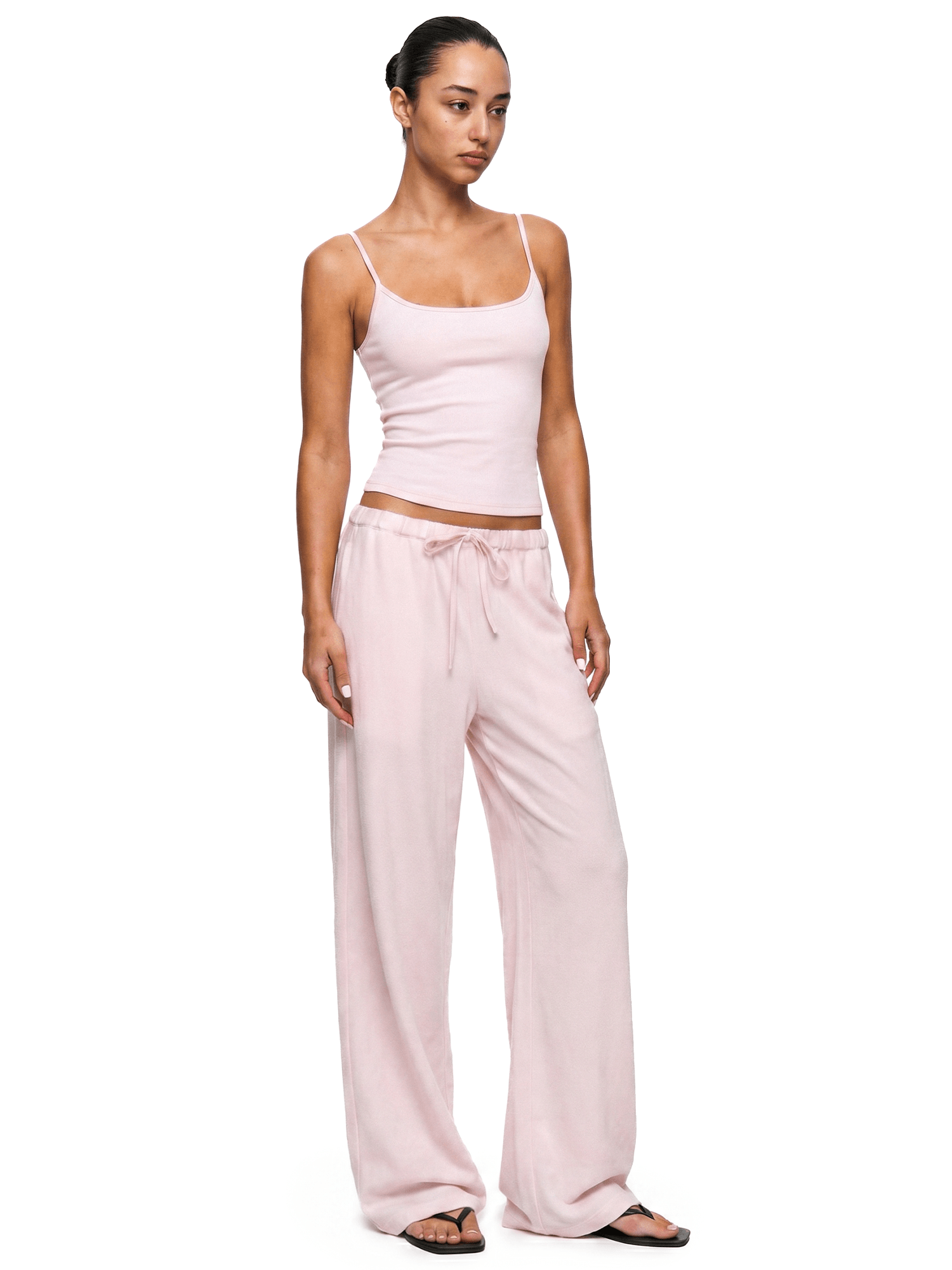Model wearing FDR Studios cyber Y2K soft baby pink camisole vest and baggy high-waisted sweatpants.