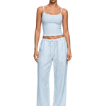 Model wearing FDR Studios industrial minimalist ice light blue spaghetti strap camisole and slouchy lounge pants.