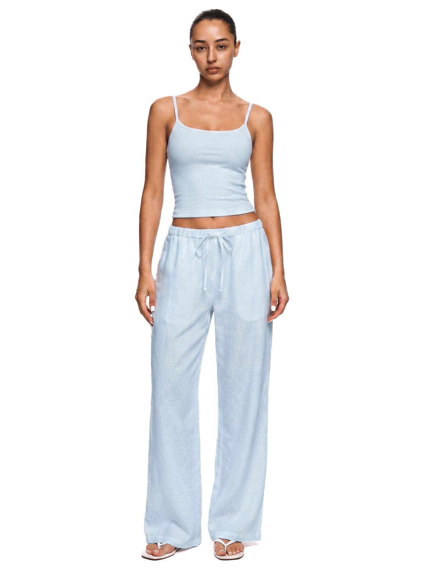 Model wearing FDR Studios industrial minimalist ice light blue spaghetti strap camisole and slouchy lounge pants.
