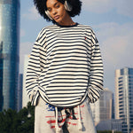 HypeCord men’s black and white horizontal striped long-sleeve T-shirt, styled with a red beanie and burgundy wide-leg trousers.