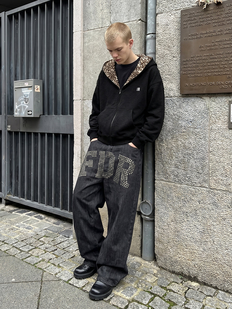 Male model in FDR black leopard hoodie and baggy graphic trousers in urban setting.
