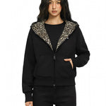 Female model wearing FDR leopard-lined black hoodie in a dynamic high-street pose.