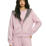 Female model wearing pink cropped zip-up sweatshirt with leopard fur contrast.