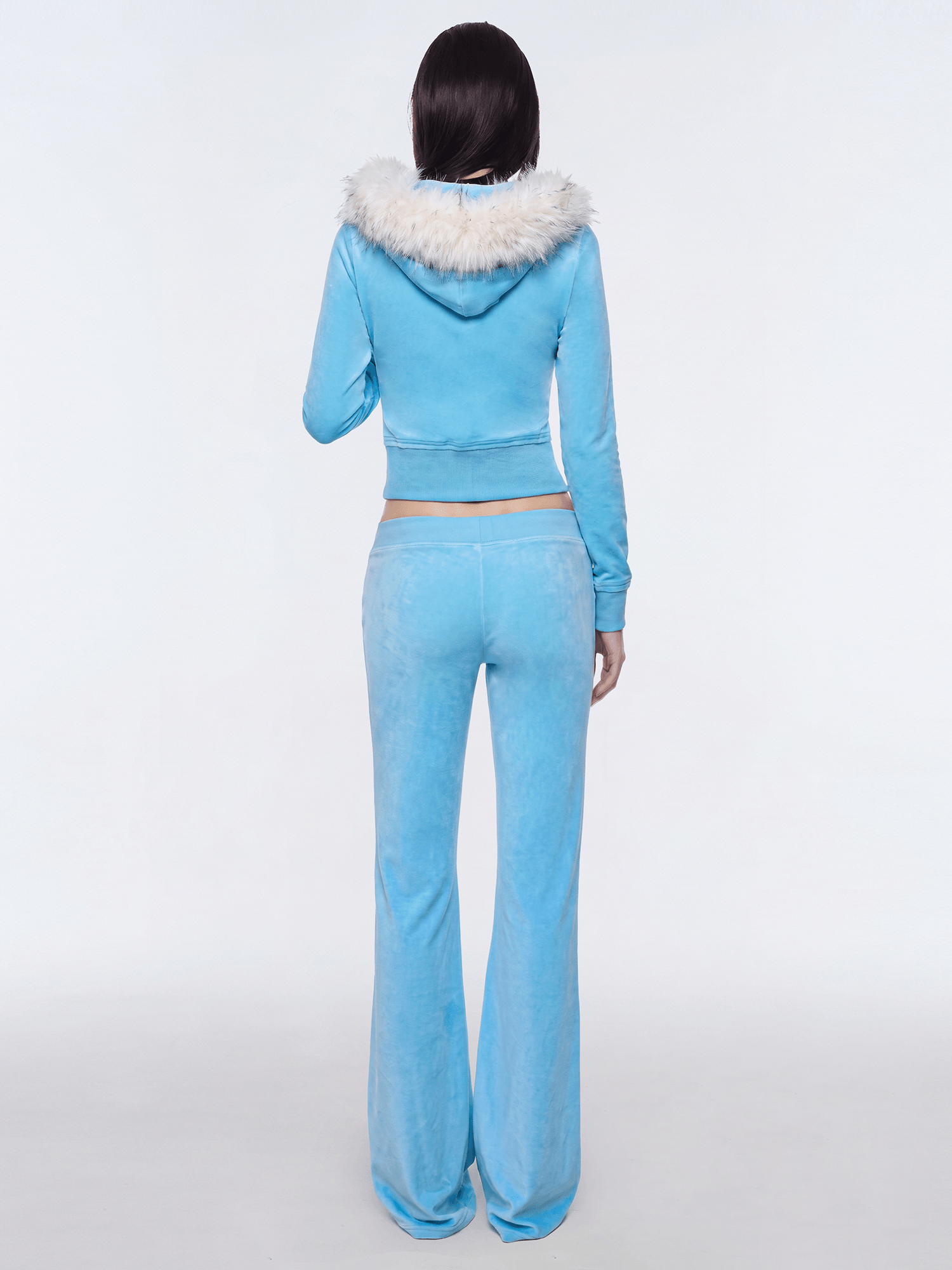 Back view of model wearing light blue Y2K plush zip hoodie with faux fur hood