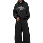 Full-length view of a streetwear outfit featuring a black baggy hoodie with star logo and oversized wide-leg pants.