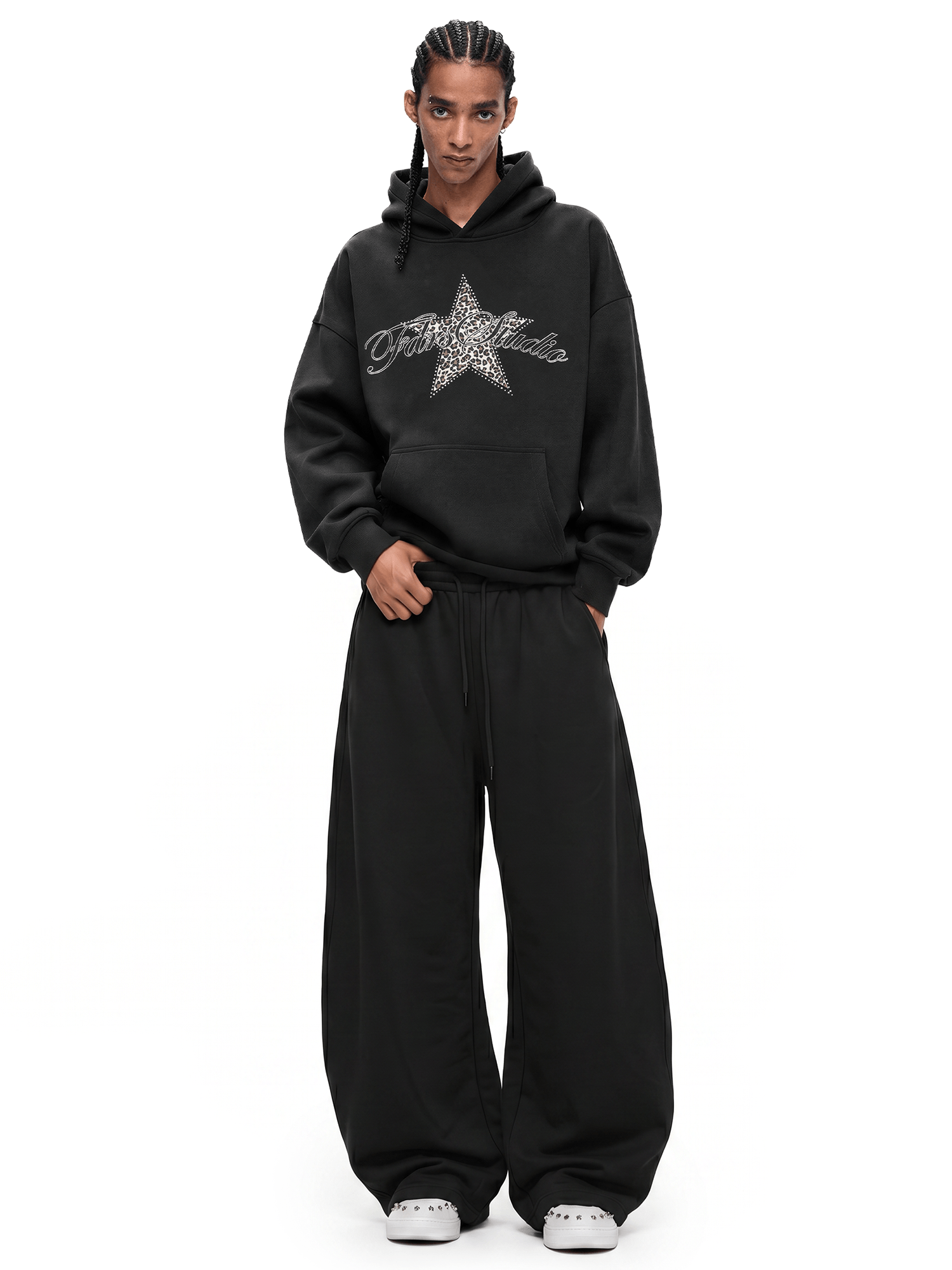 Full-length view of a streetwear outfit featuring a black baggy hoodie with star logo and oversized wide-leg pants.