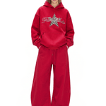 Full body studio portrait of a red graphic streetwear hoodie and black oversized wide-leg pants with side 