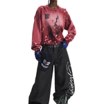 Streetwear style showcase featuring a red graphic crewneck sweatshirt and ultra-wide-leg black trousers.