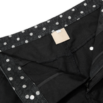Close-up of the waistband on black wide-leg pants featuring metallic stud detailing and premium stitching.