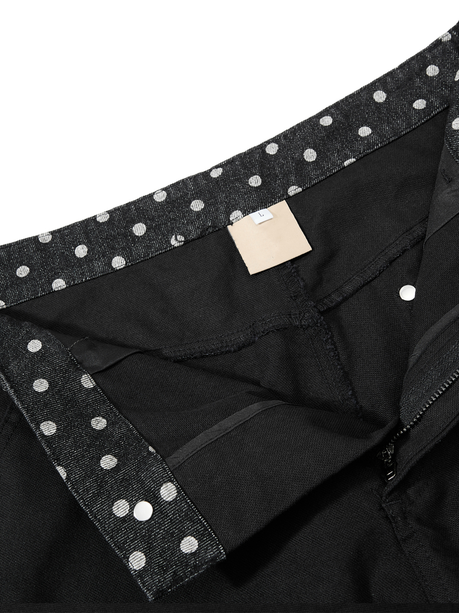 Close-up of the waistband on black wide-leg pants featuring metallic stud detailing and premium stitching.