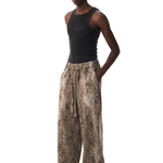 Front view of a model styled in a black tank top tucked into wide-leg leopard print pants with a relaxed fit.
