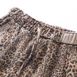 Detail shot of the elasticated waistband and drawstring closure on the leopard print wide-leg pants.