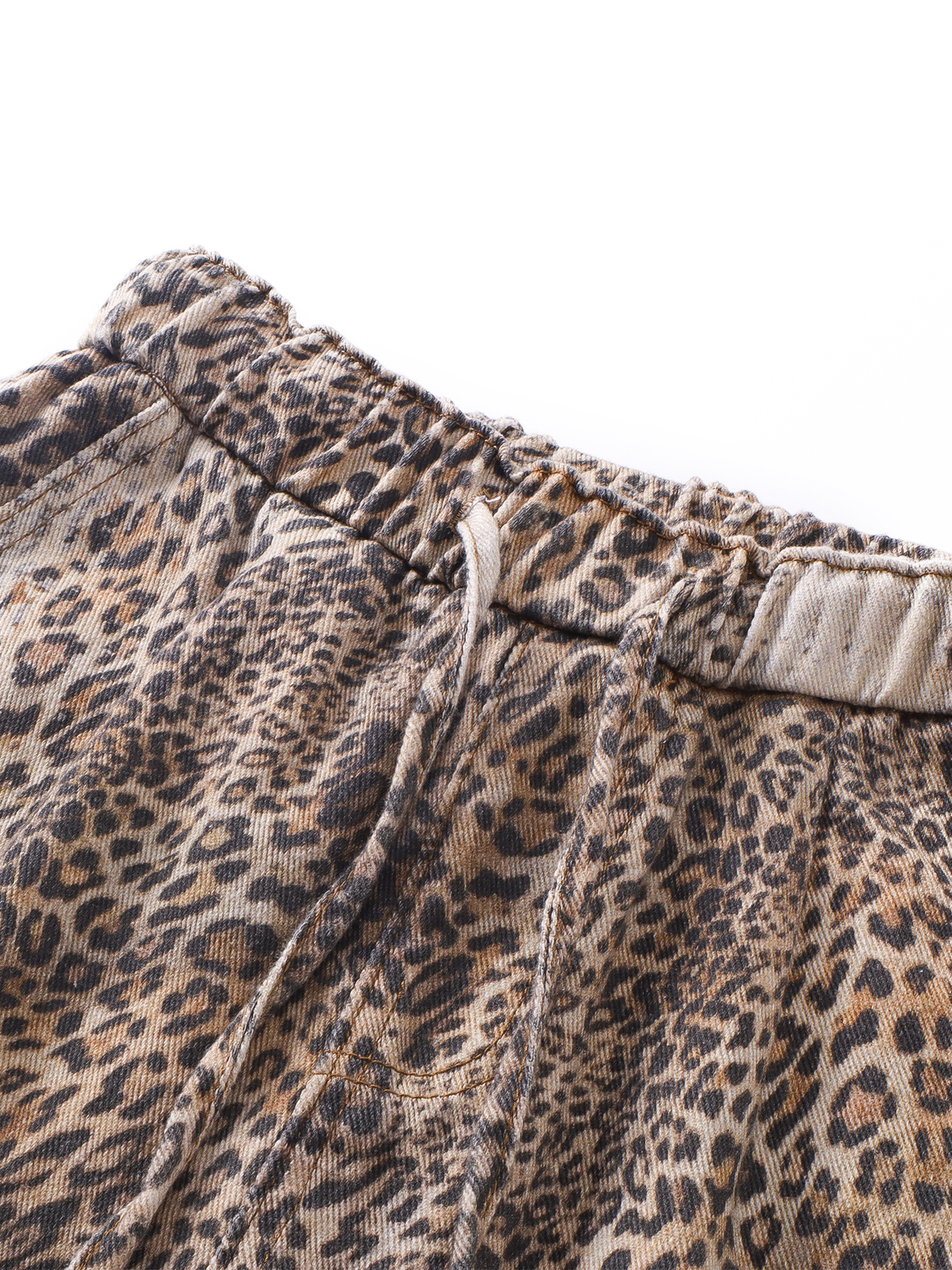 Detail shot of the elasticated waistband and drawstring closure on the leopard print wide-leg pants.
