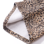 Close-up detail of the leg opening hem on the leopard print trousers, highlighting the fabric texture and inner lining.