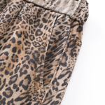 Macro shot of the leopard print fabric and side pocket detail of the oversized trousers.