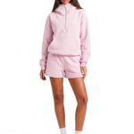 Close-up of the oversized pink hoodie showing the architectural high-funnel neck and silver zipper.