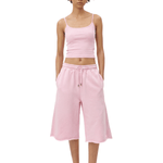 Full-body front view of a model wearing a light pink spaghetti-strap camisole cropped top and matching light pink loose knee-length shorts.