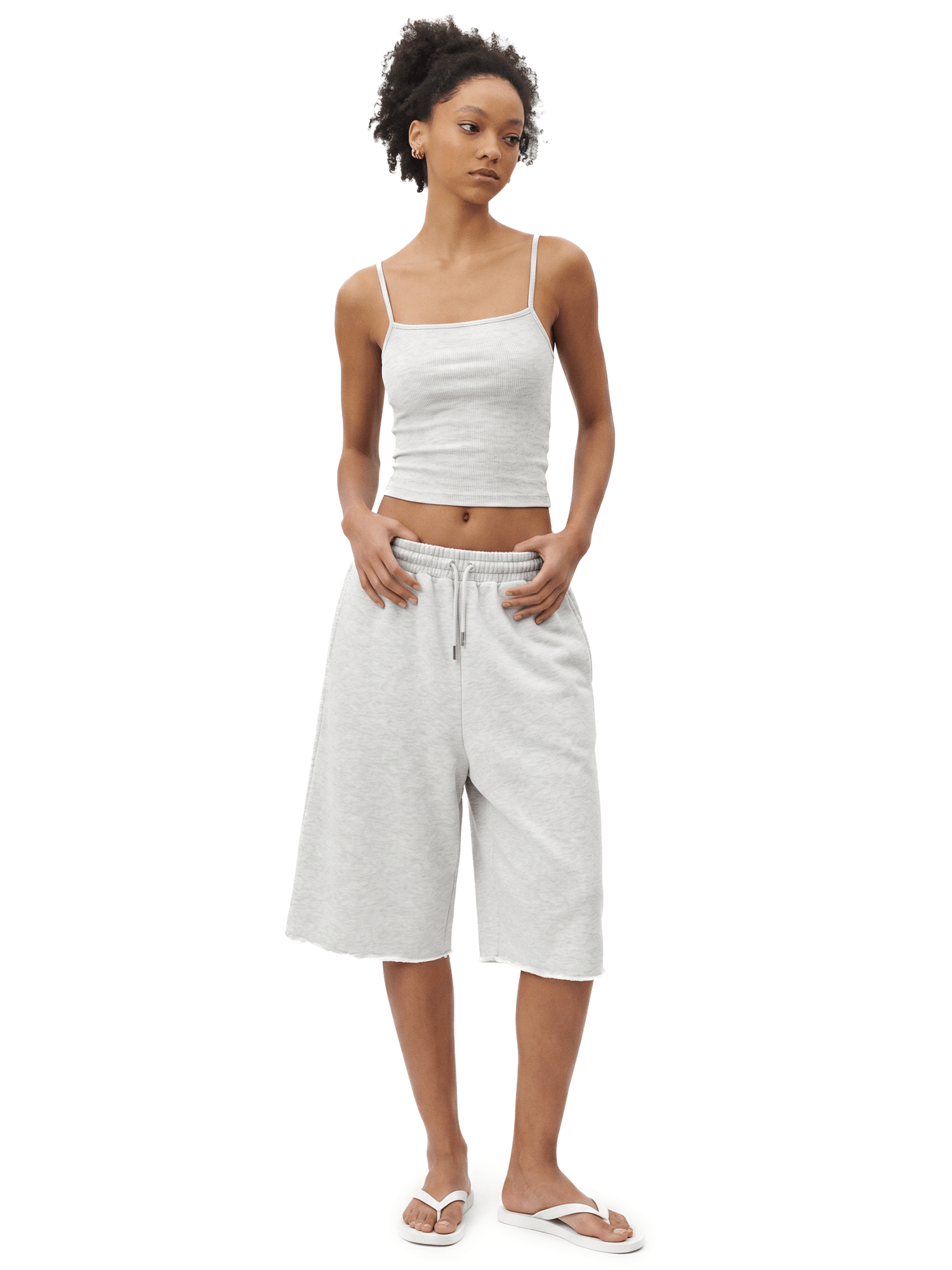 Full-body front view of a model wearing a light gray spaghetti-strap camisole cropped top and matching light gray loose knee-length shorts.