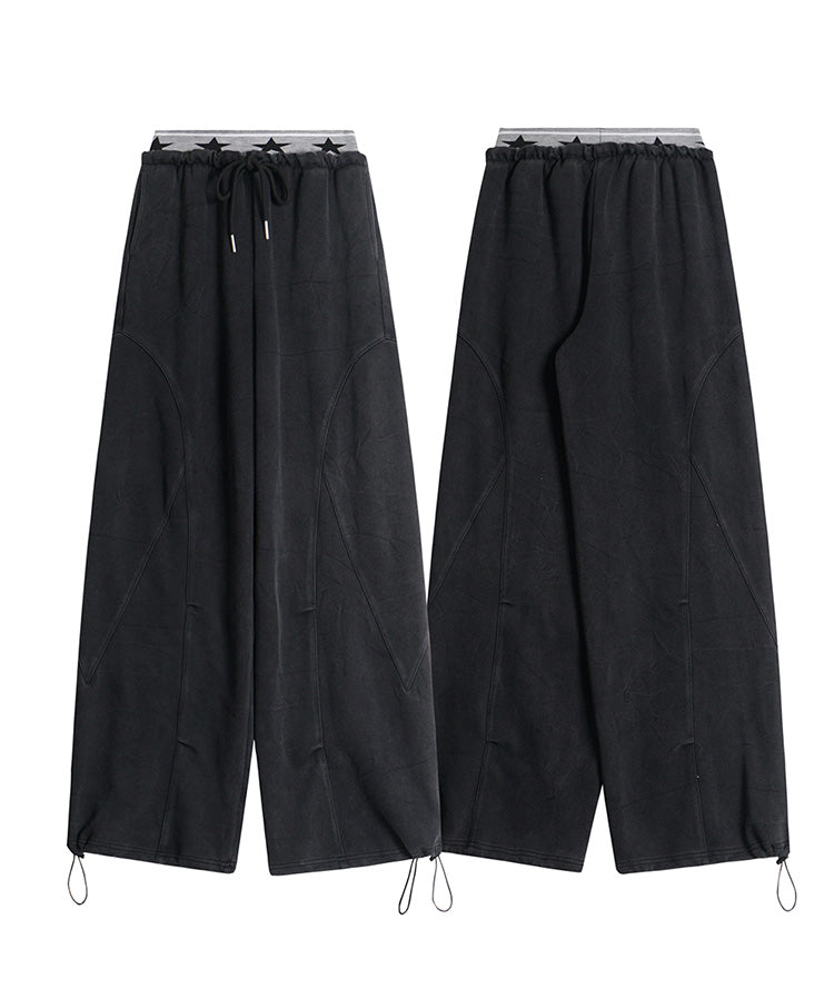 Front and back product view of black wide-leg sweatpants featuring adjustable drawstring cuffs.