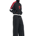 Side profile of a male model showcasing the oversized fit and drape of black wide-leg streetwear trousers.