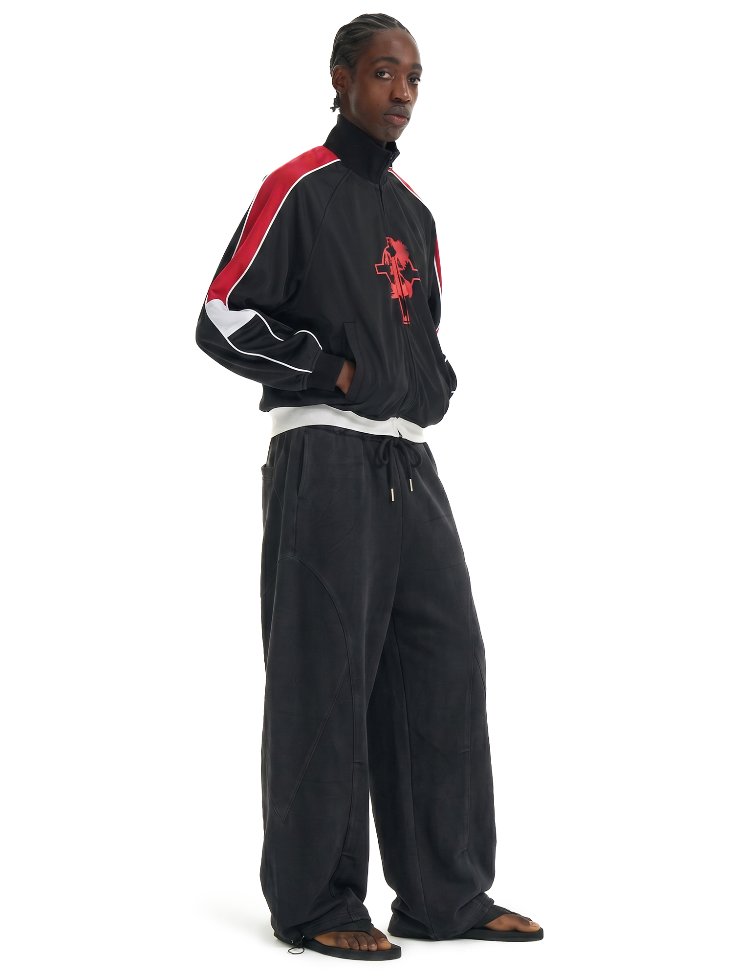 Side profile of a male model showcasing the oversized fit and drape of black wide-leg streetwear trousers.
