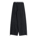 Back view of black minimalist wide-leg pants showing the clean construction and fabric texture.