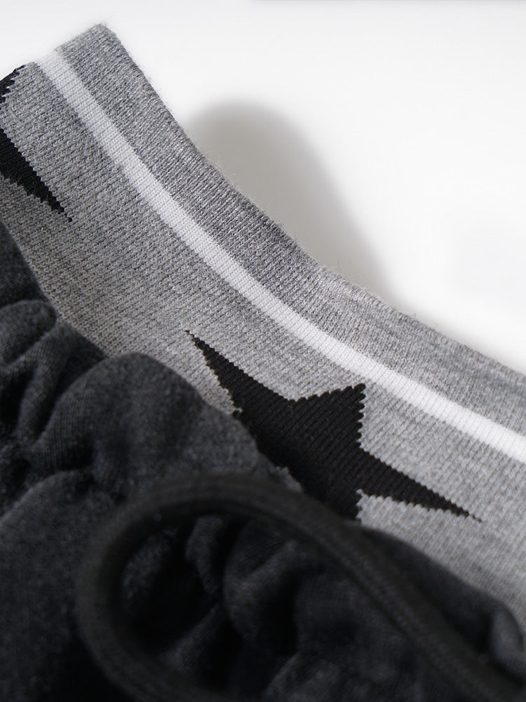Close-up detail of the waistband featuring a grey elastic band with a star logo pattern.