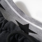 Close-up detail of the waistband featuring a grey elastic band with a star logo pattern.