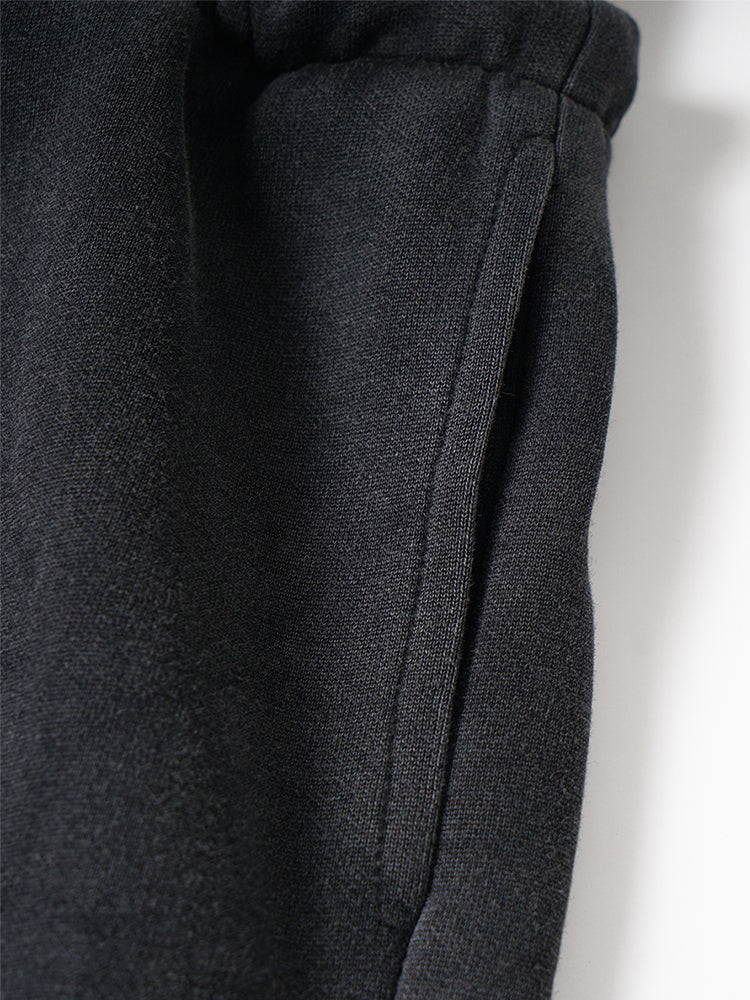 Close-up of dark gray fabric with a visible seam on a light background