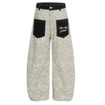 Front view of light beige leopard print wide-leg pants with contrasting black cargo pockets.