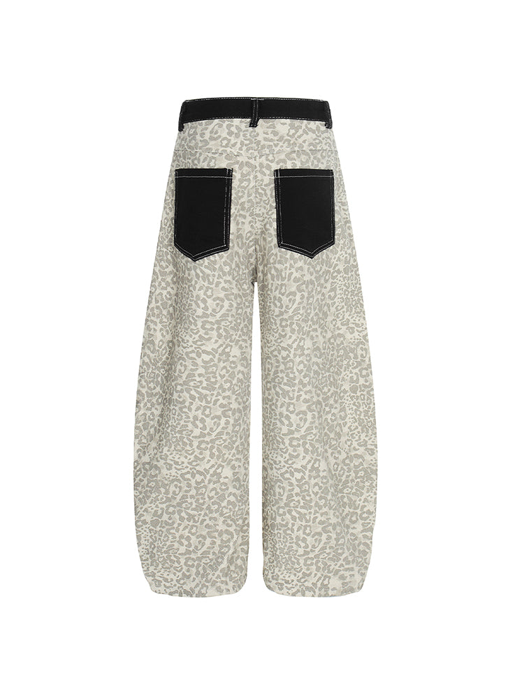 Close-up of the black pocket on leopard print pants featuring a white script brand logo.