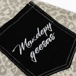 Black patch with 'Maxdepy geessas' text on a patterned background