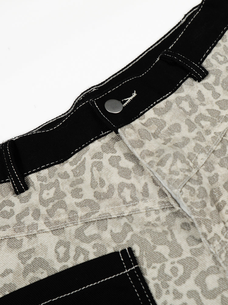 Close-up of the leopard print trouser waistband showing the black trim, metal button, and security tag.