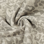 Macro shot of the leopard print fabric texture showing the soft knit or cotton weave.