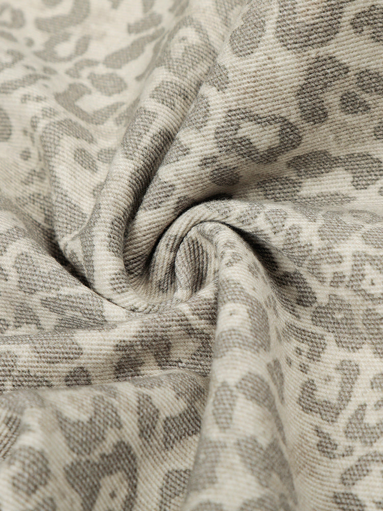 Macro shot of the leopard print fabric texture showing the soft knit or cotton weave.