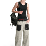 Person wearing a black tank top and gray pants with a backpack on a white background