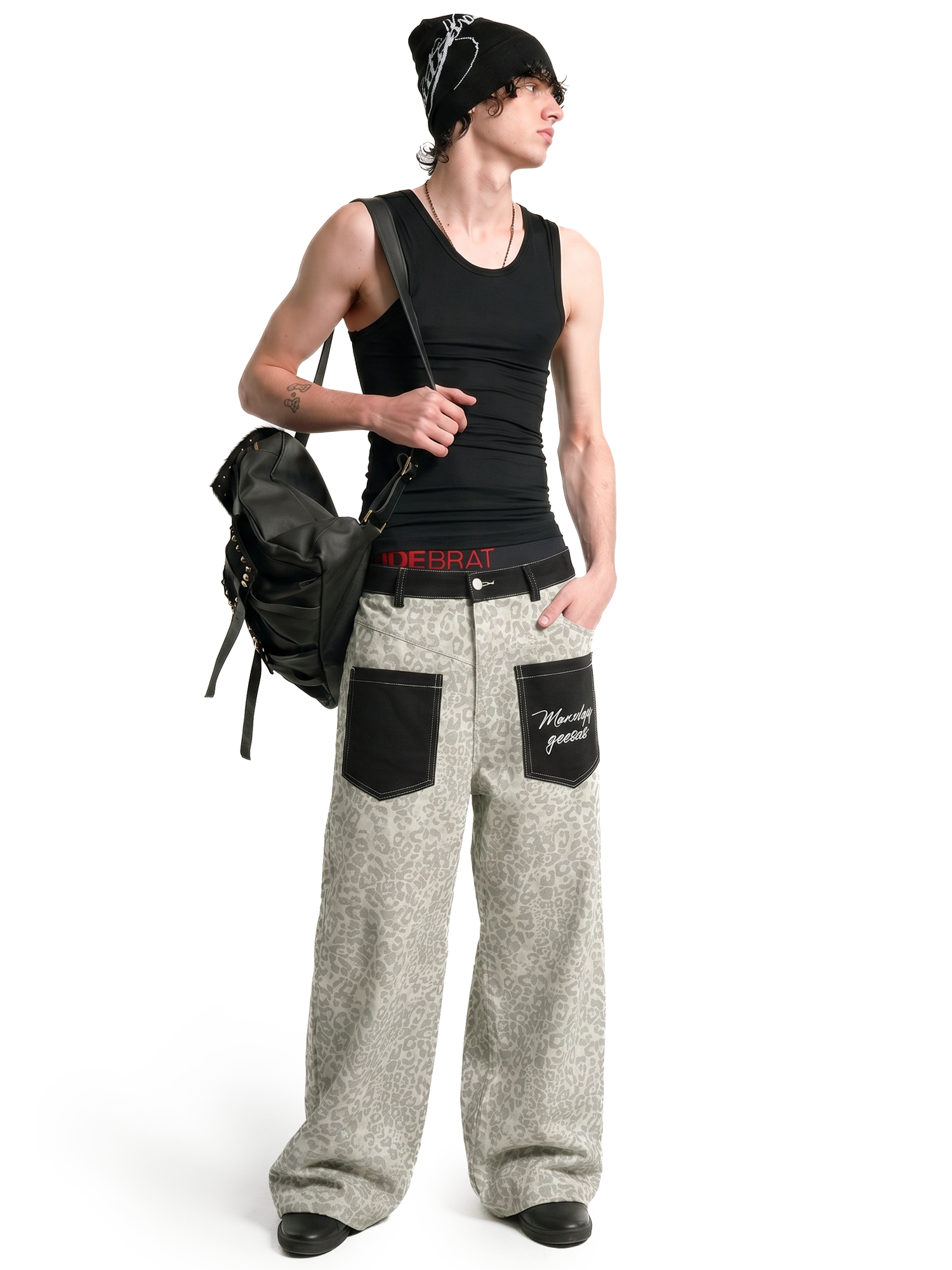 Person wearing a black tank top and gray pants with a backpack on a white background