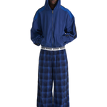 Full body shot of model wearing Liveshouse Iconic Plaid Baggy Pants in blue with oversized hoodie and logo waistband.