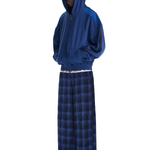 Side view of model styling blue checkered streetwear lounge pants with a relaxed baggy fit.