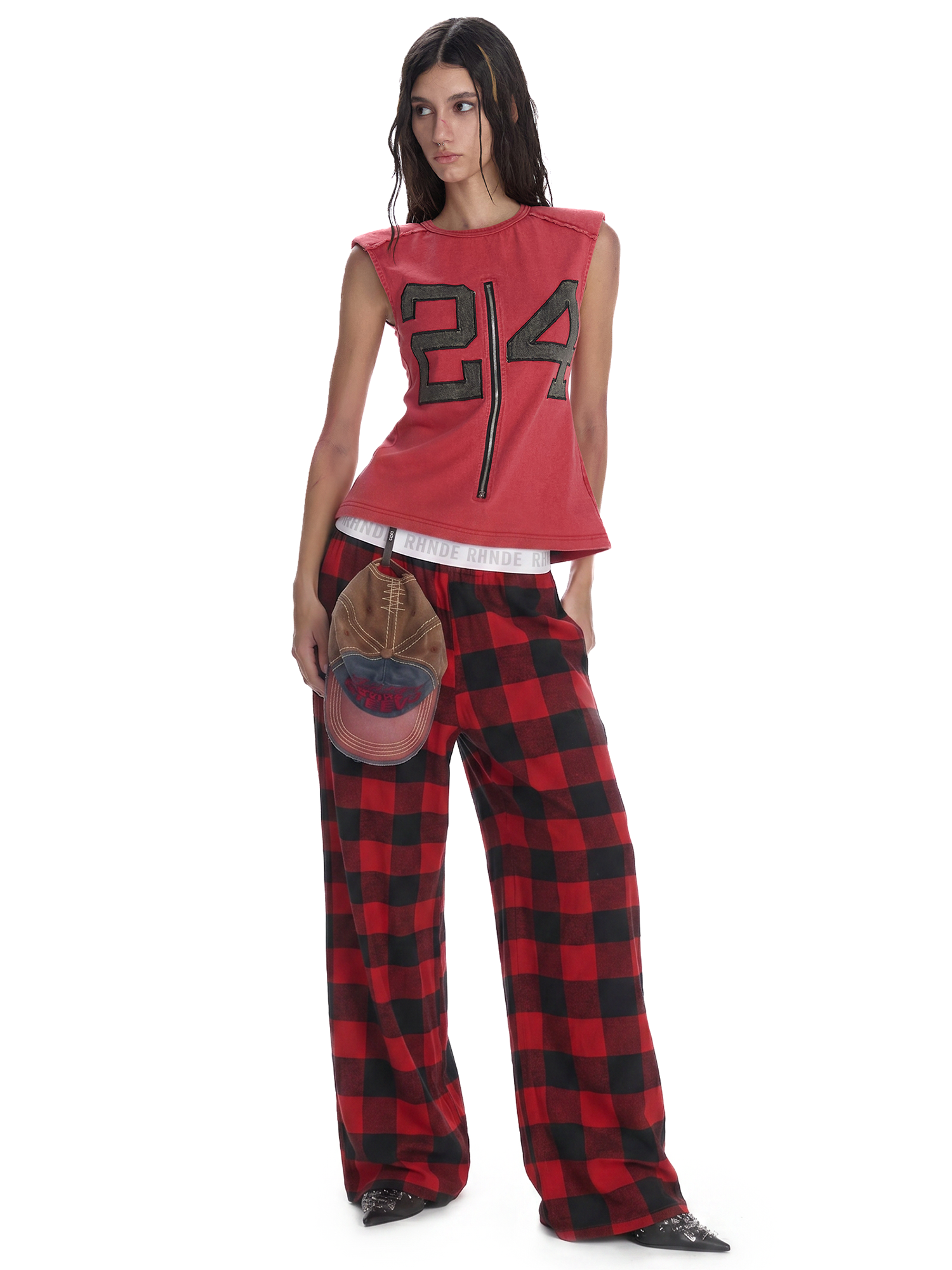 Female model wearing red plaid baggy pants with a cropped top for a Y2K streetwear look.