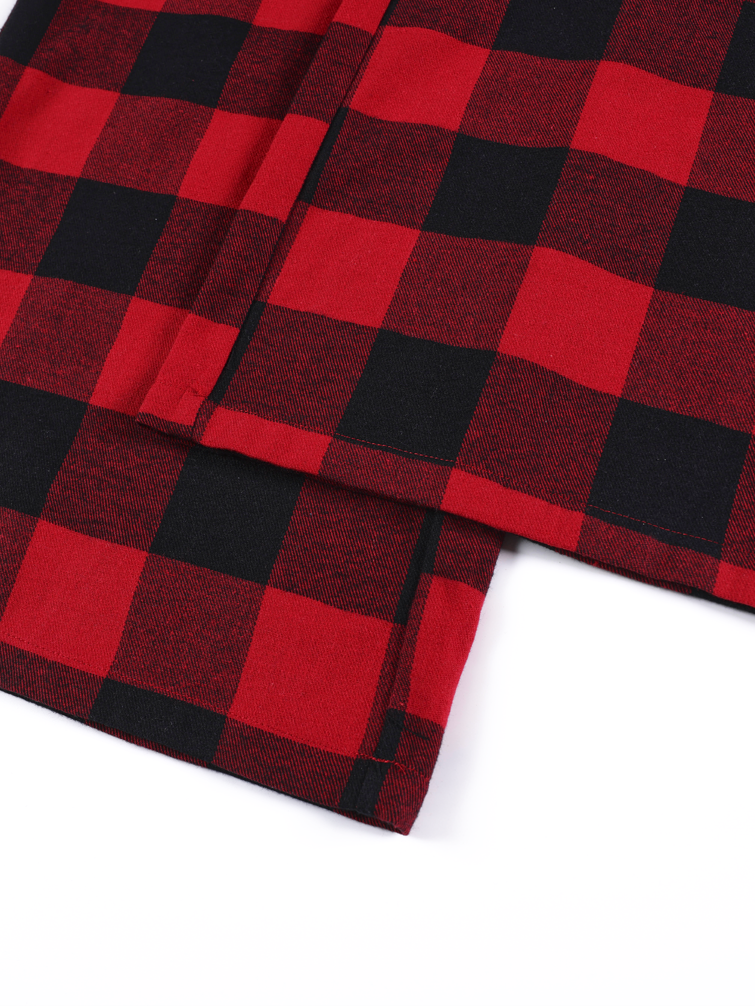 Detailed shot of the hem and heavy-weight fabric texture of red plaid streetwear pants.